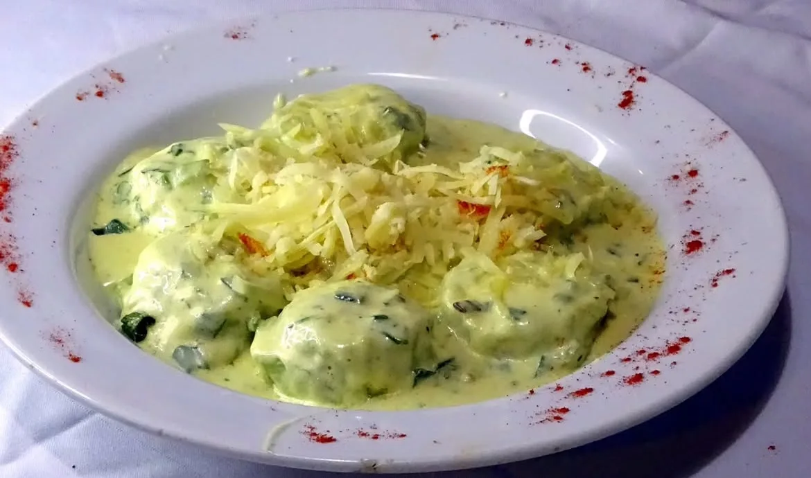 Ñoquis de espinaca con salsa de crema y queso rallado